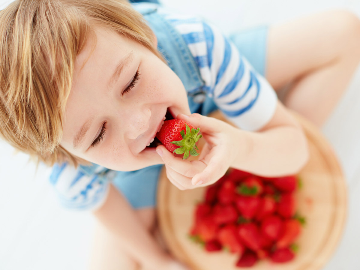 дитина їсть полуницю