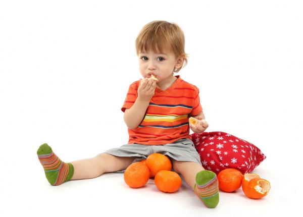 дитина їсть апельсин